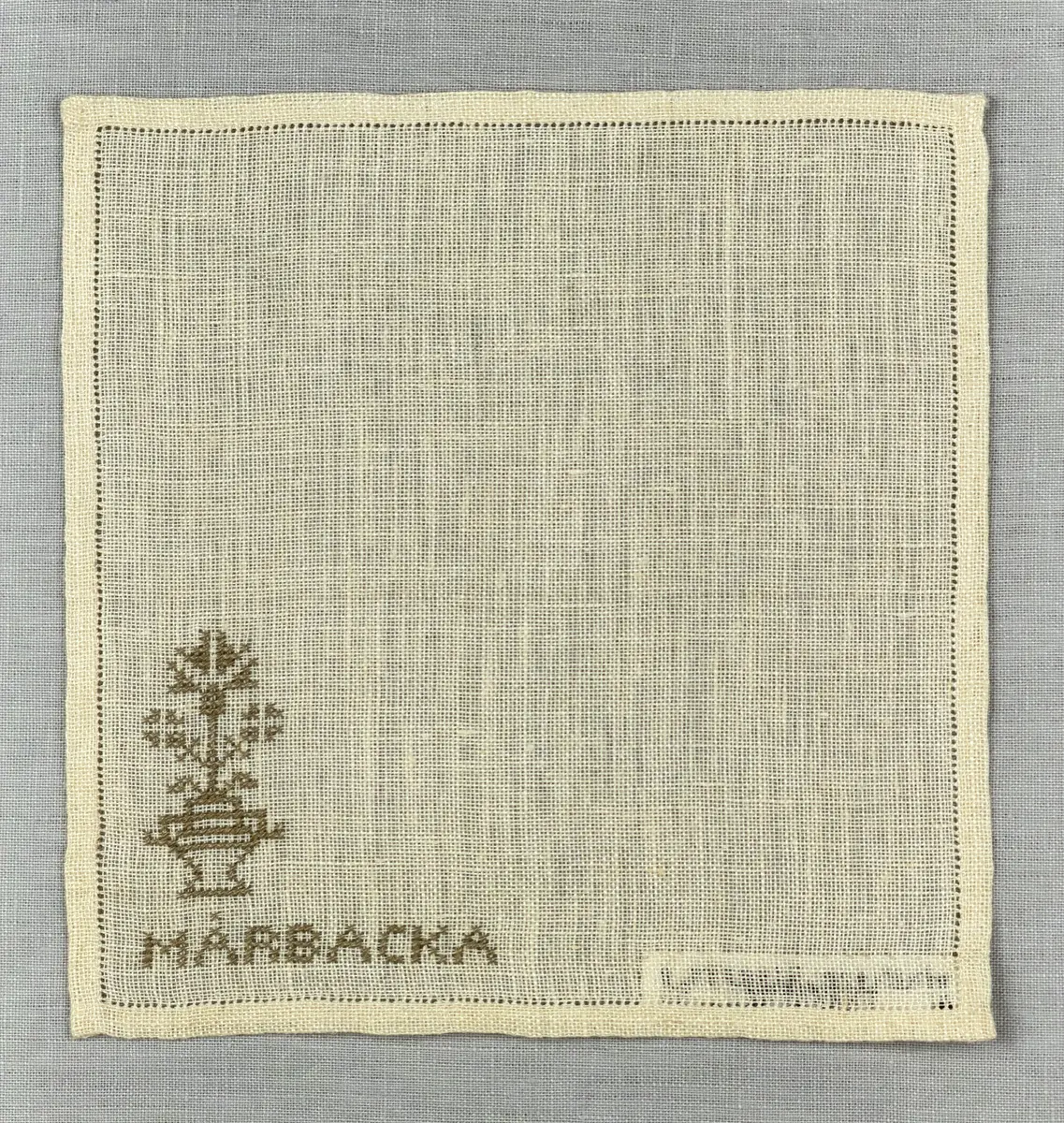 Duk gjord av linneväv med 12tr/cm i tuskaft och broderi utfört med lingarn i korsstygn sydda över två trådar. Duken har 6mm bred dubbelvikt fåll runt om fastsydd med en enkel hålsöm samt raka hörn, vilka är sömmade med kaststygn.
