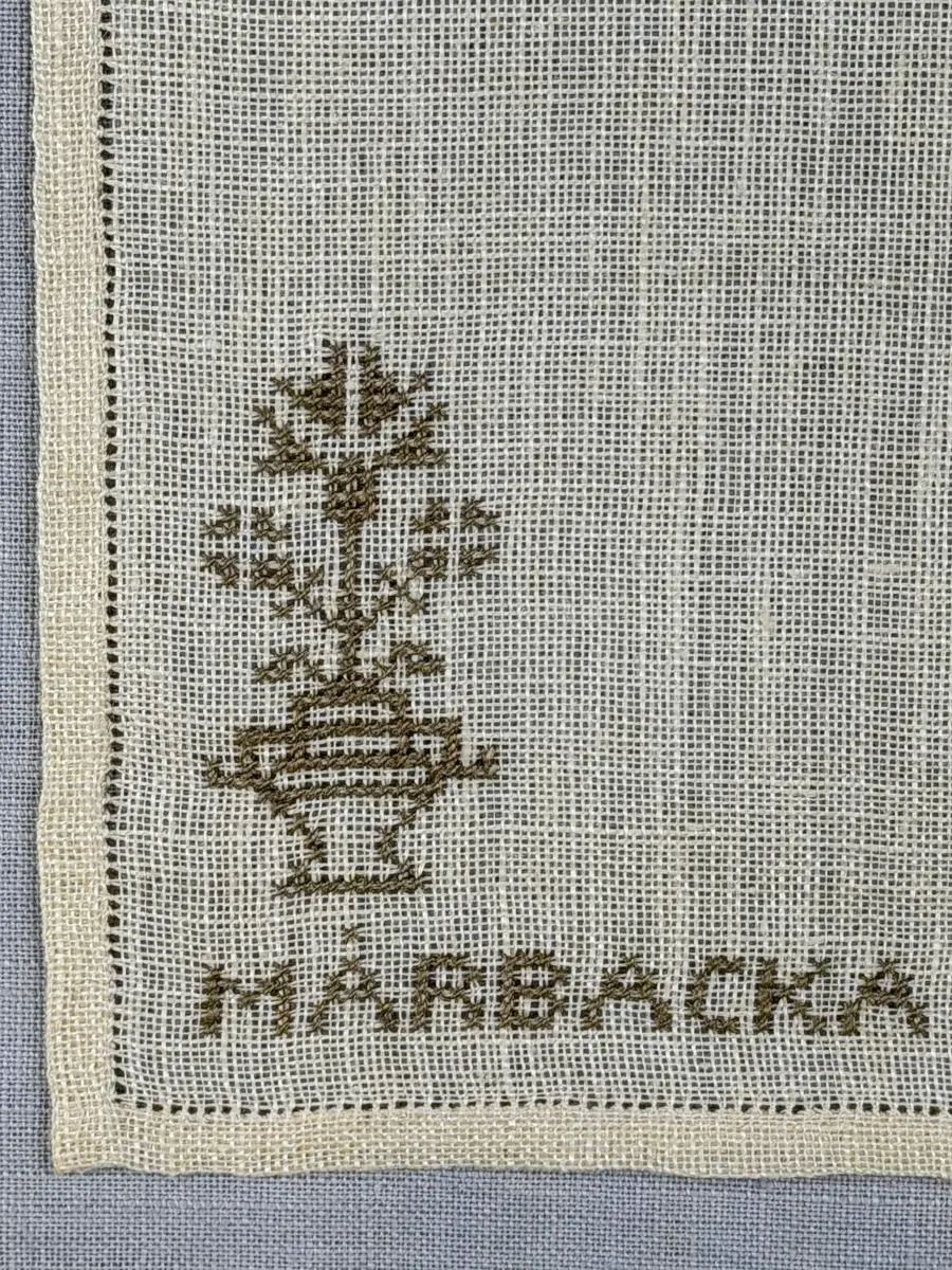 Duk gjord av linneväv med 12tr/cm i tuskaft och broderi utfört med lingarn i korsstygn sydda över två trådar. Duken har 6mm bred dubbelvikt fåll runt om fastsydd med en enkel hålsöm samt raka hörn, vilka är sömmade med kaststygn.
