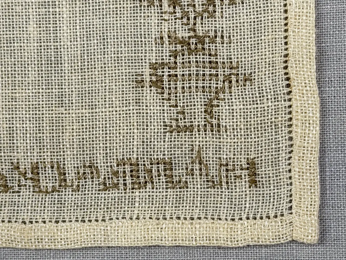 Duk gjord av linneväv med 12tr/cm i tuskaft och broderi utfört med lingarn i korsstygn sydda över två trådar. Duken har 6mm bred dubbelvikt fåll runt om fastsydd med en enkel hålsöm samt raka hörn, vilka är sömmade med kaststygn.
