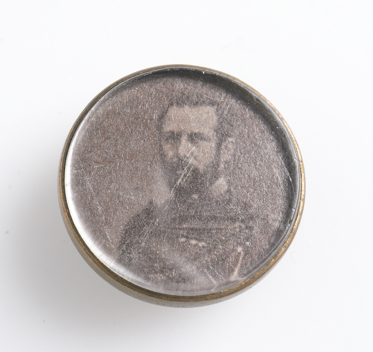 Knapp av mässing med bild föreställande Konung Carl XV.

Inskrivet i huvudkatalog omkring 1895.