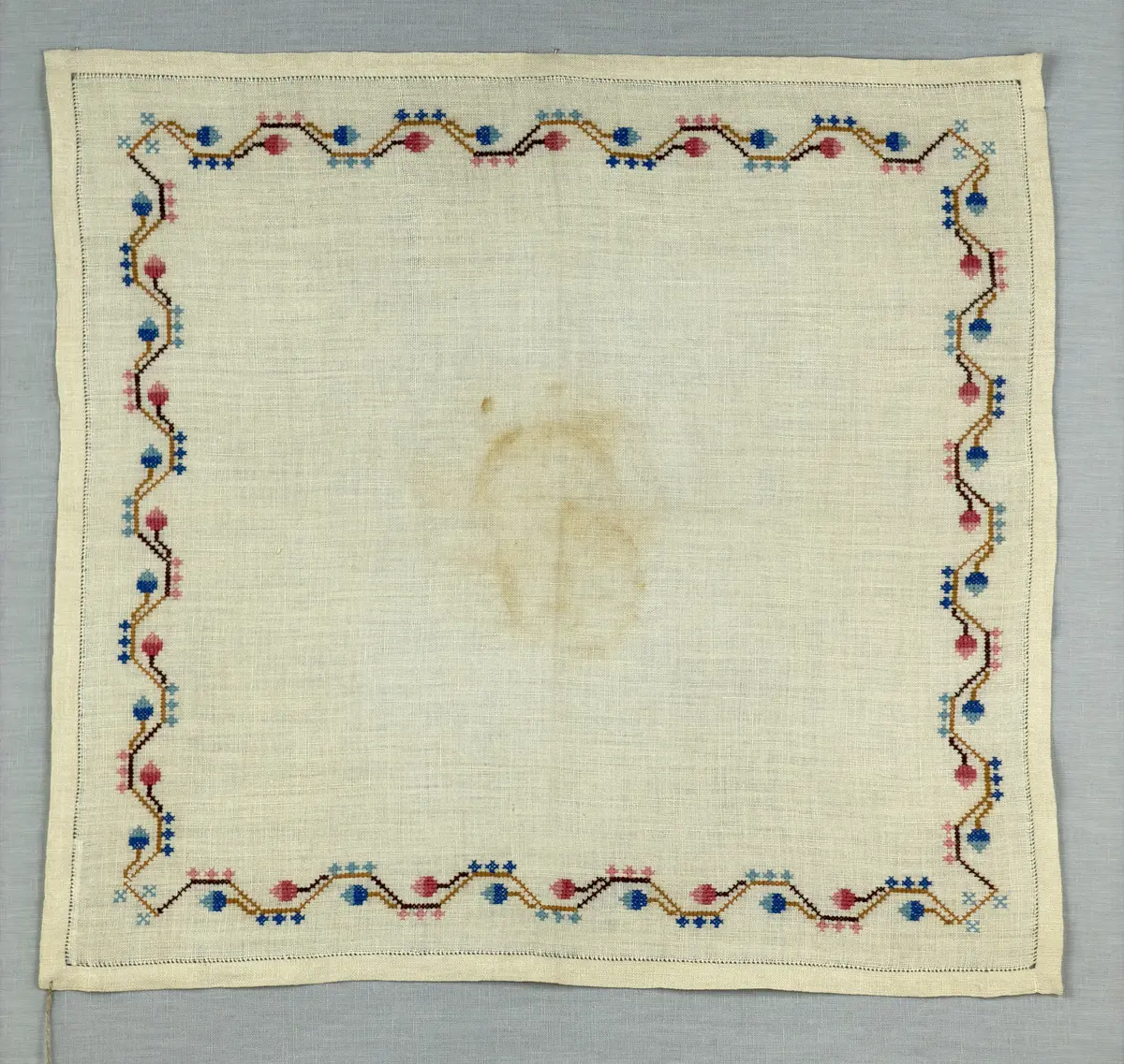 Duk gjord av linneväv med 15tr/cm i tuskaft och broderi utfört med dubbelt bomullsgarn i korsstygn sydda över tre trådar. Duken har 11mm bred dubbelvikt fåll runt om fastsydd med en enkel hålsöm samt sneda hörn, vilka är sömmade med kaststygn.
