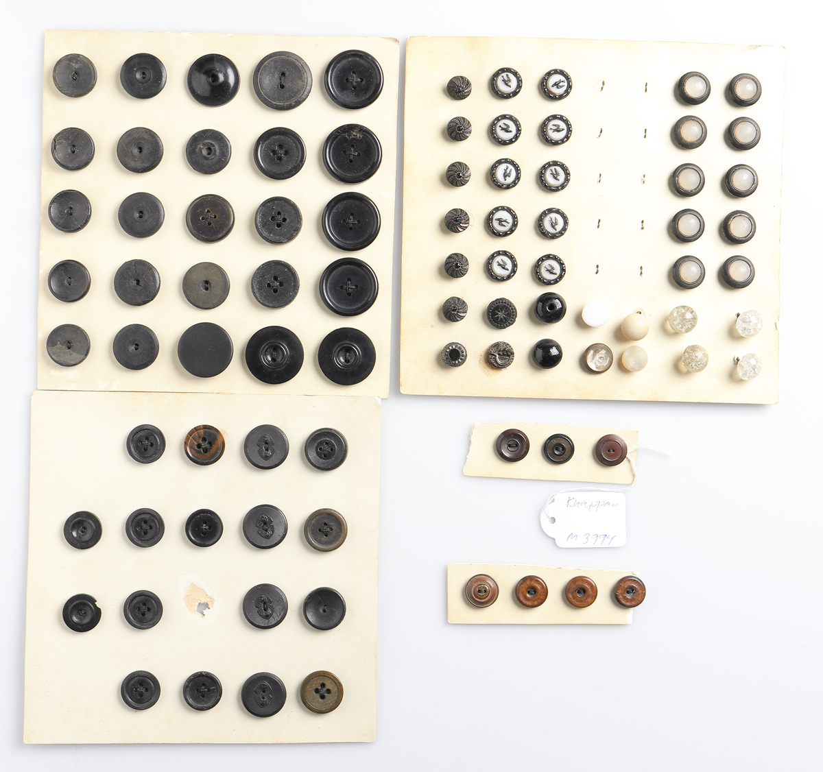 Knappsamling, uppsatt på 16 st. kartongskivor. Knappar av olika modeller och material.
Inskrivet i huvudkatalog 1919.