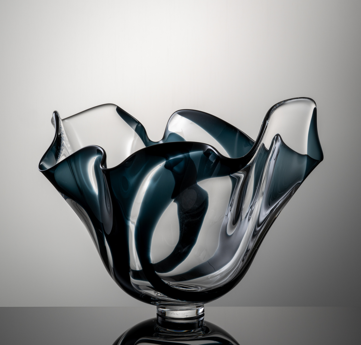 Skål med veckad form, profilerad mynningskant och låg fotklack. Dekor i form av brett, midnattsblått färgband.
Formgivare: Lars Hellsten.