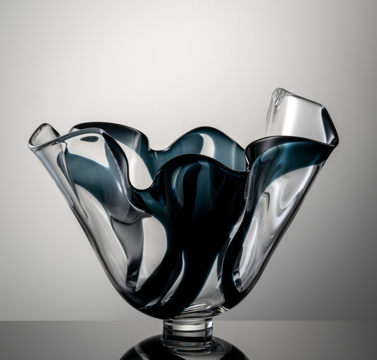 Skål med veckad form, profilerad mynningskant och låg fotklack. Dekor i form av brett, midnattsblått färgband.
Formgivare: Lars Hellsten.