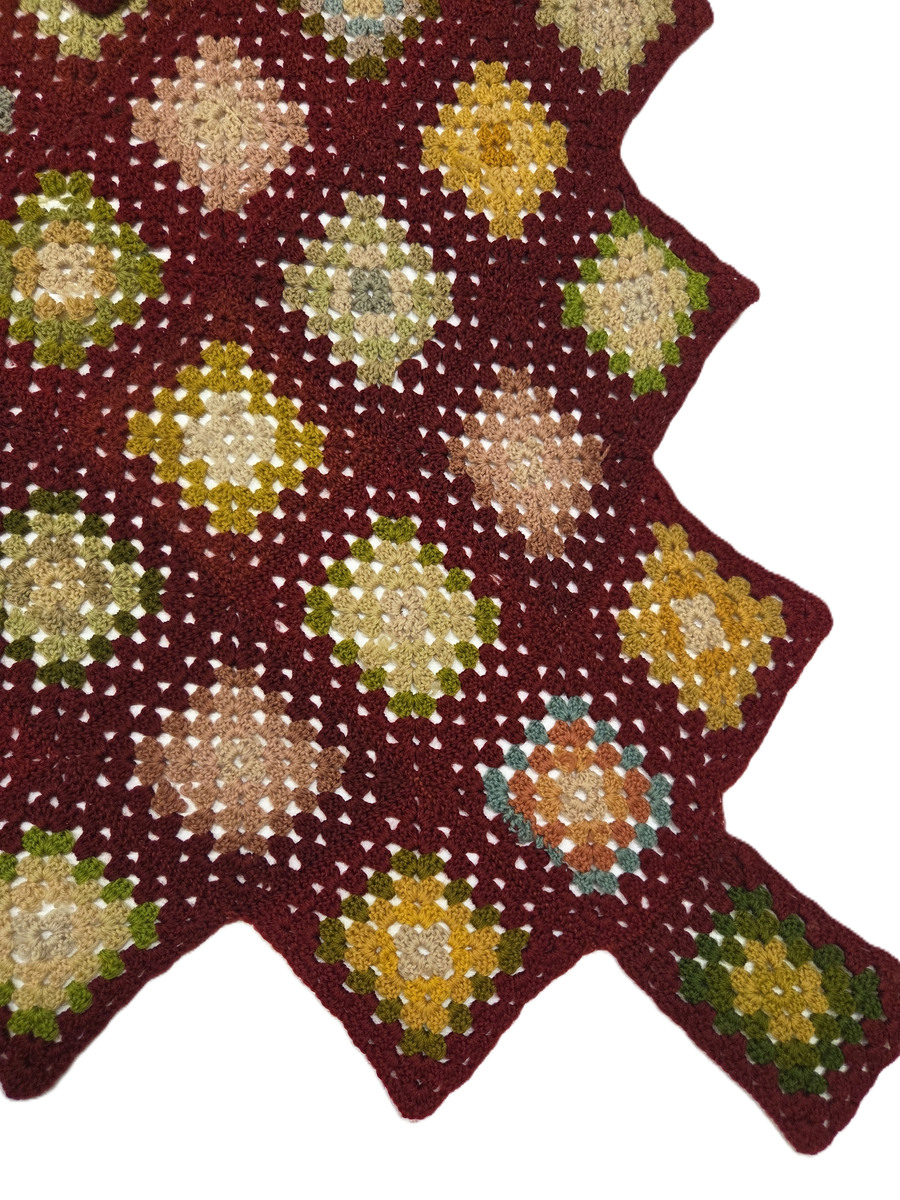 Filt. Virkad uddkantig filt. Vinröd bottenfärg med rutor i gult, grönt, rosa och ljusblått.