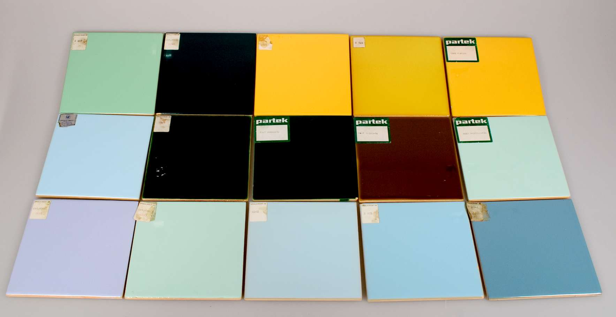 Modellsamling bestående av 25 st enfärgade,kvadratiska, tunna kakelplattor av gulbrännande lergods med blank glasyr i flera blå och gula nyanser, i grönt, ljuslila, ljusgrått och vitt. 1 st med breda ränder på baksidan och öppen UE-stämpel, 24 st med rak SWEDEN-stämpel och rund UE-stämpel samt nummer, varav 6 st med pappersetiketter i vitt och grönt med texten: PARTEK och 19 st med svart text: UPSALA-EKEBY och nummer.