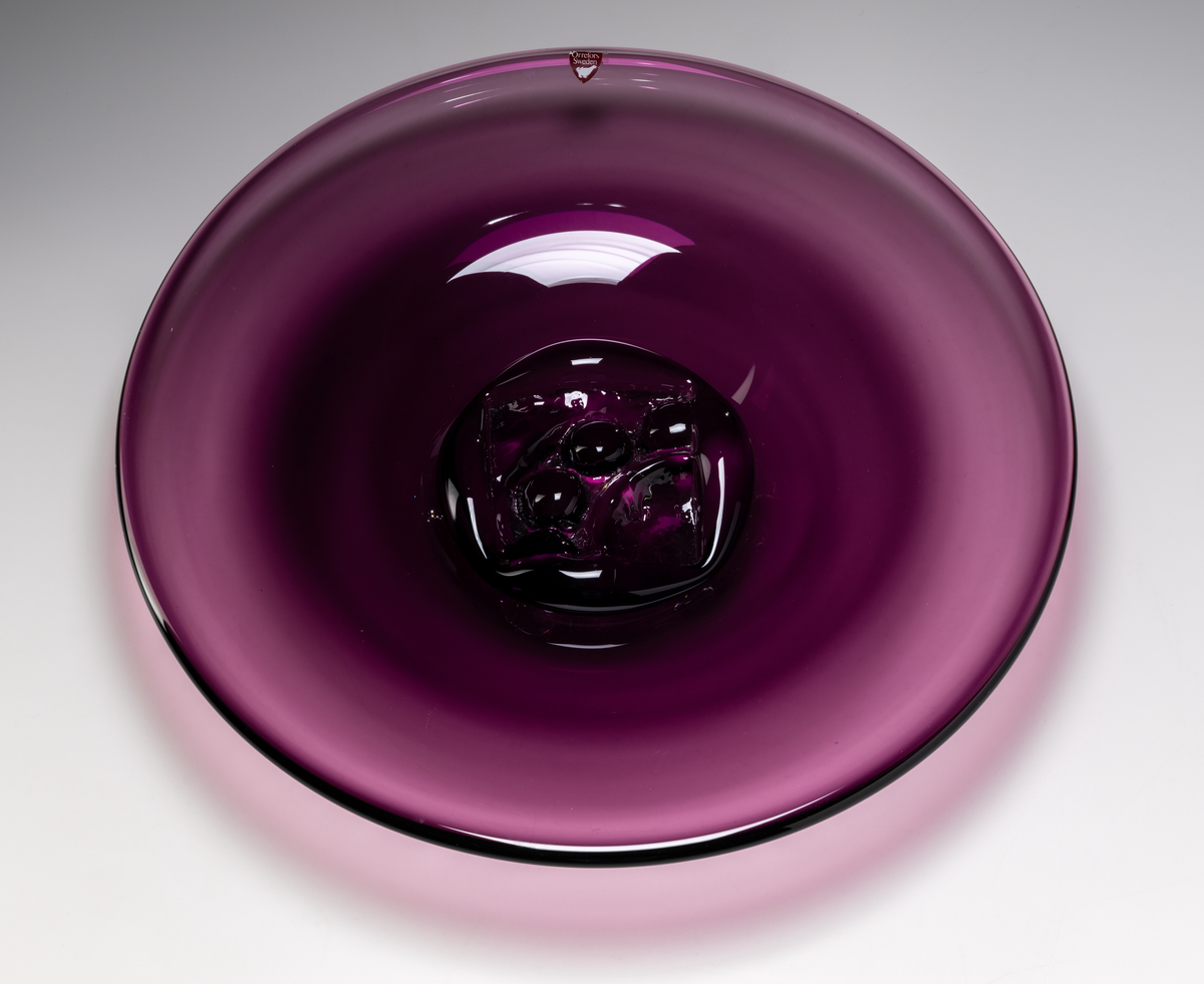 Formgivare: Lars Hellsten. Fat i vinröd nyans. Rund klockform med sigill i mitten.