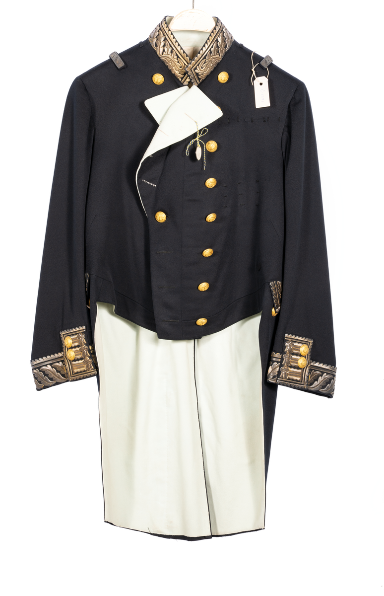 Amiralsfrack med vitt sidenfoder i ryggen samt kläde på slag och skört. Krage, ärmar och ficklock med generalsgalon. En innerficka, två bakfickor. 8 förgyllda knappar med ankare och tre kronor. Fyra knapphål på var sida. I skörten sex knappar och tre på vardera ficklocket.