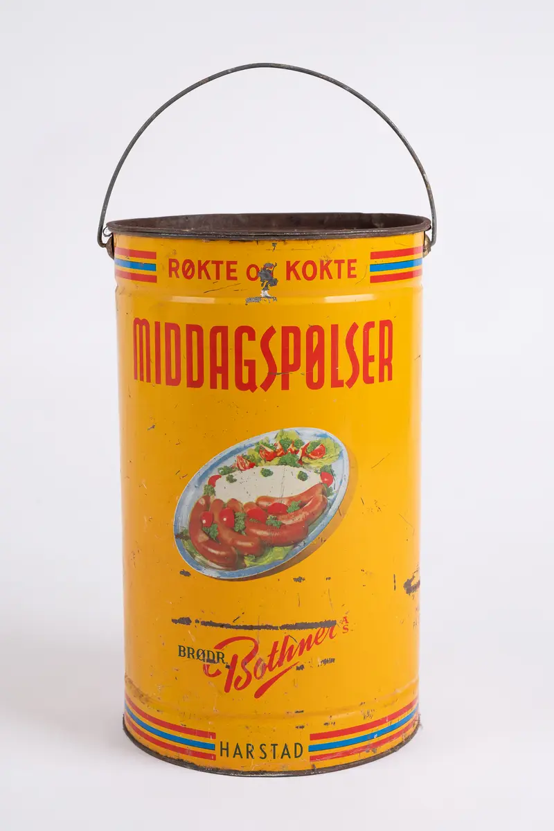 Spann. Sylinderformet. Emaljert blikkmetall. Lokk med riller. Fleksibel bøylehank i metall. Illustrasjon på 2 sider av serveringsfat med pølser. Skrift.