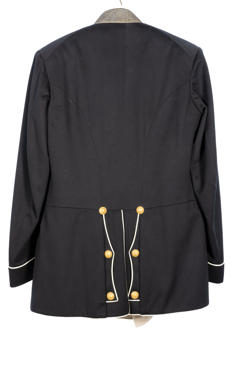 Amiralsvapenrock, vitfodrad med vita slag av kläde, vita passpoaler. Galonerad krage med tre broderade silverstjärnor. Åtta knappar på varje sida, tre på ärmen samt sex i ryggen. En inner- och två bakfickor.
Har tillhört Kung Oscar II.