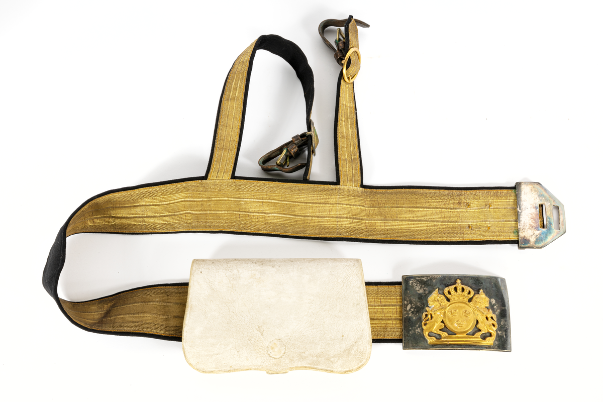 Skärp, bred guldgalon, med korta, sabelremmar av guldgalon, allt fodrat å svart kläde. Spänne av  försilvrad plåt med krönt litet riksvapen omgivet av lejon, förgyllt. Små läderremmar med mässingssöljor för fäste  till sabeln. Tillhörande kartusch/sabeltaska, attrapp, av vitt kalvskinn.