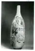 Vas dekorerad med illustrationer av olika steg inom krukmakeriet från Bo Fajans, omkring 1900-talets mitt.