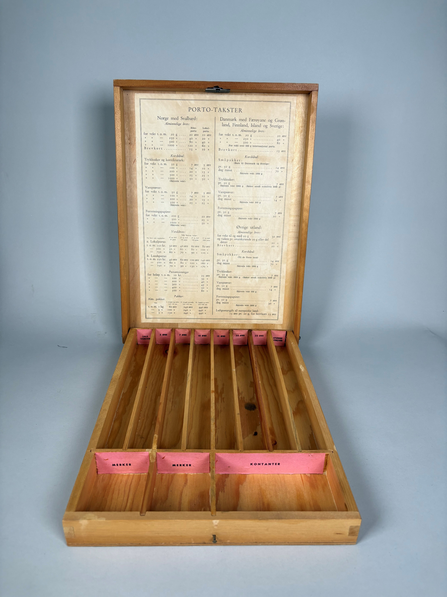 Rektangulær kasse i tre som kan åpnes med festet, stående lokk. På utsiden er det festet en rød merkelapp med motiv av et frimerke og tekst "PORTO-KASSE".

Kassen er inndelt i flere rom for oppbevaring. På innsiden av lokket er det pålimt en portotakst.