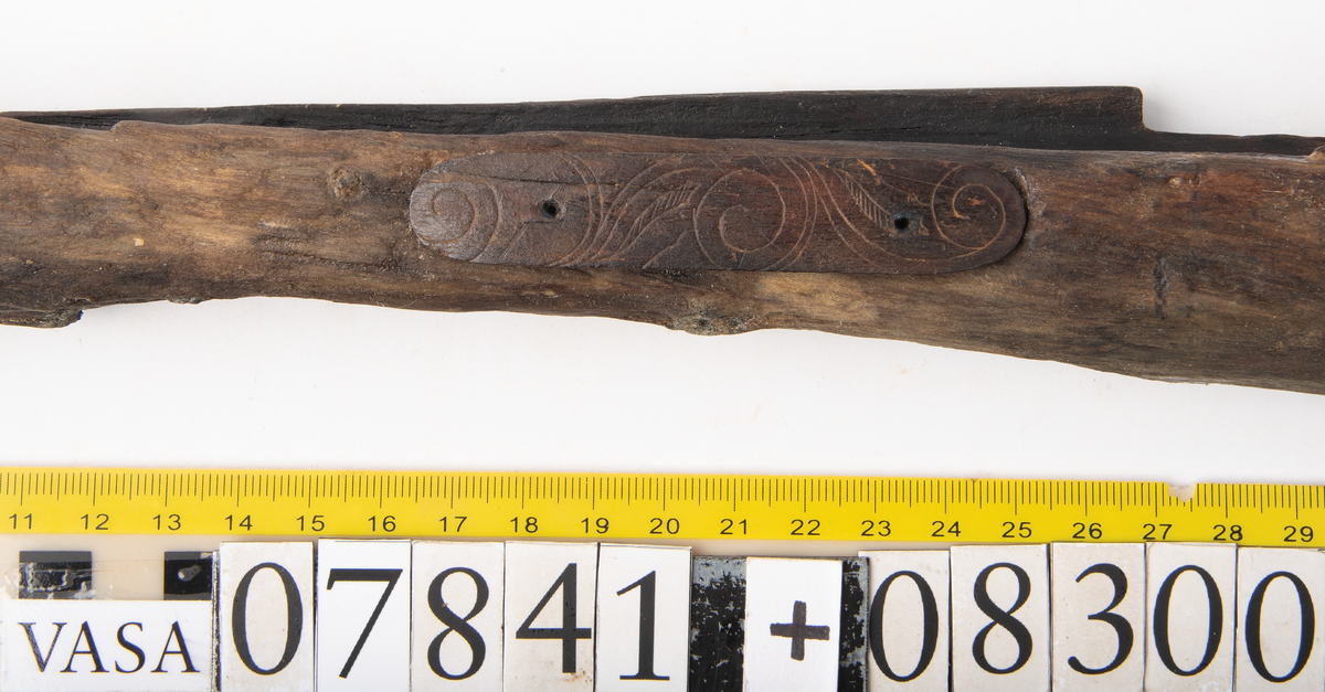 Avlångt beslag av ben med stiliserat rankornament. Graverad.