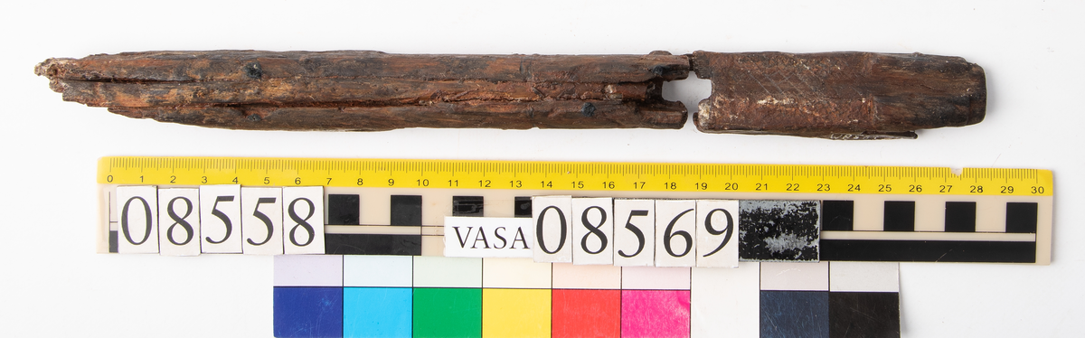 Bit av bösspipa. Bruten i bägge ändar. Diagonalt rutmönster på ena sidan.