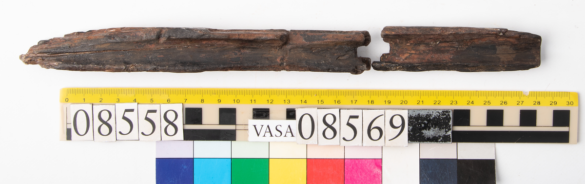 Bit av bösspipa med kvarsittande laddstake. Bruten och splittrad.