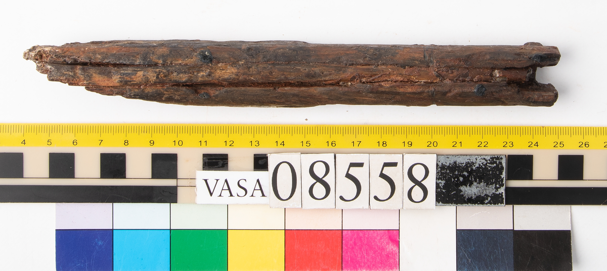 Bit av bösspipa med kvarsittande laddstake. Bruten och splittrad.