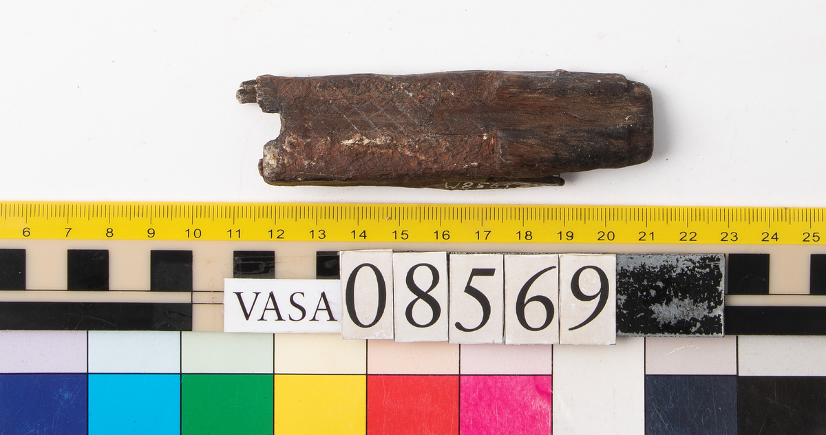 Bit av bösspipa. Bruten i bägge ändar. Diagonalt rutmönster på ena sidan.