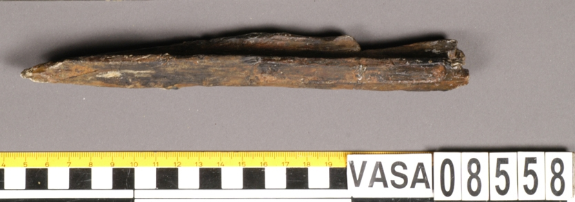 Bit av bösspipa med kvarsittande laddstake. Bruten och splittrad.