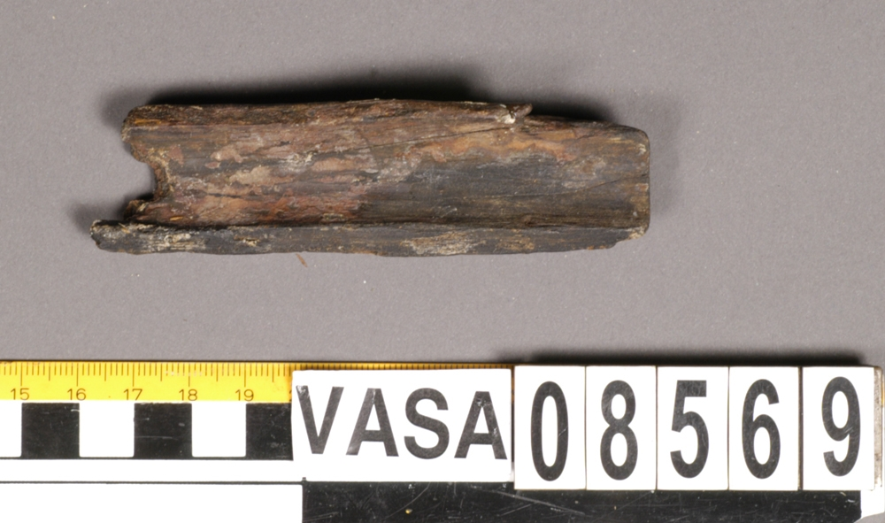 Bit av bösspipa. Bruten i bägge ändar. Diagonalt rutmönster på ena sidan.