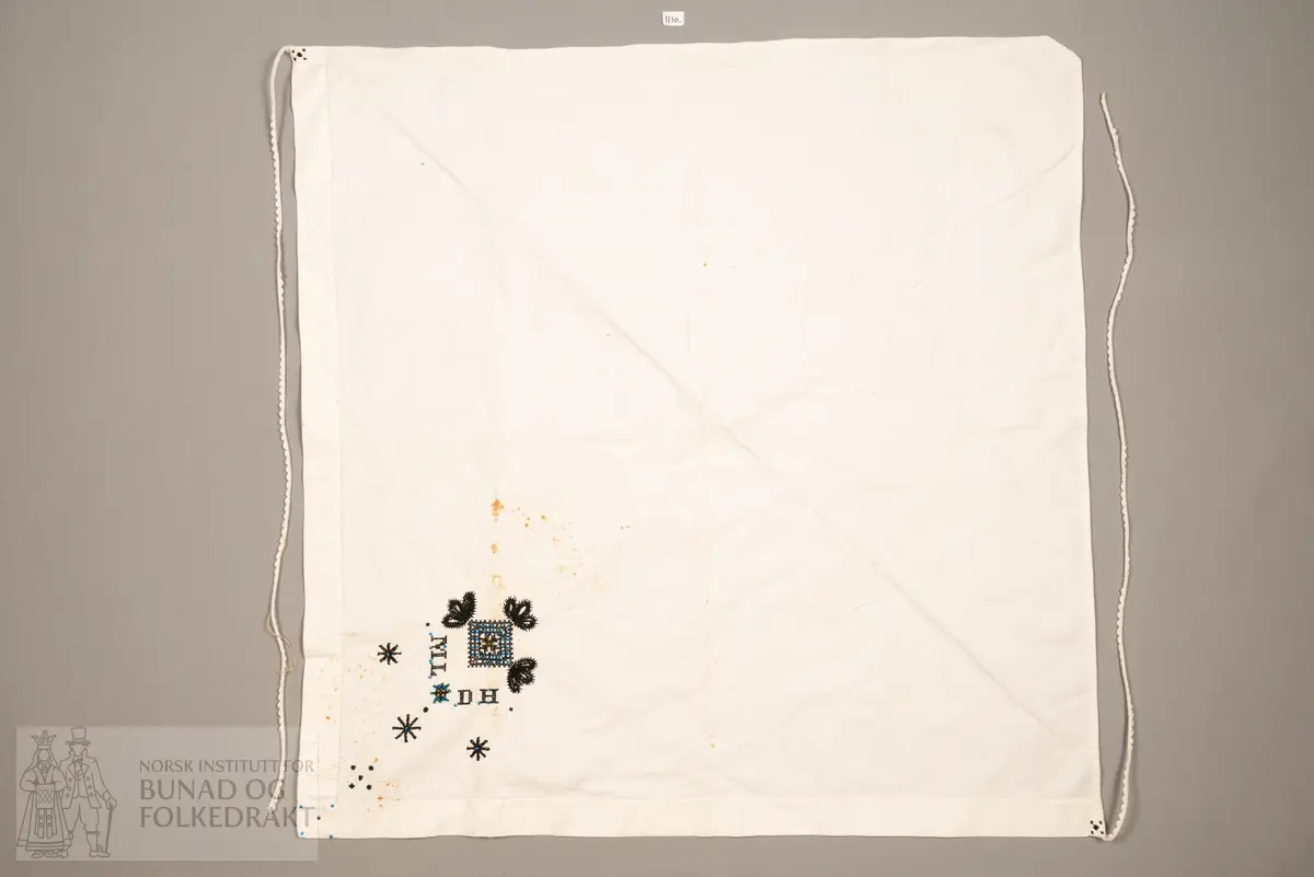 Skaut sydd av stødig, fast bomullslerret (24 tråder x 24 tråder per cm.). Bretta diagonalt. Broderi i eine snippen, av svart, tjukk silketråd og glasperler i mellomblå, mørk transparant blå, transparant grøn, transparant gul, og ei perle transparant raud.
Innbrodert med korssting initialane: "M.L.D.H."
Kjedesting, stilkesting og korssting.
Langs båe sider av den broderte snippen er bretta ein brei fald sydd ned med enkel holfald.
Også jare langs ei side og ein smalbretta fald sydd ned med små faldesting i den fjerde sida.
Knyteband av smalt, kvitt blondeband i bomull.

Om skautet i "Hovdatyet" av Eli Drønen: "Skautet var av lerret og sydd med svart tråd i korssting i nakken, ca. 67 x 67 cm. Skautebanda vart festa i to endar av skauten, dei er i ripsvevnad 58 cm x 1,3. Skautet vart lagt i trekant og sett på hua. Det vart kryssa bak, og skautspissane rakk til øyrene, og vidare vart skautebanda kryssa framme ca. 3 cm innpå skautet og ført vidare og knytt bak under skautet. Endene av banda vart putta innunder skautet. (...) Skautet var brukt utanpå rundhua, når dei gjekk til kyrkje, i gjestebod og i bryllaup."