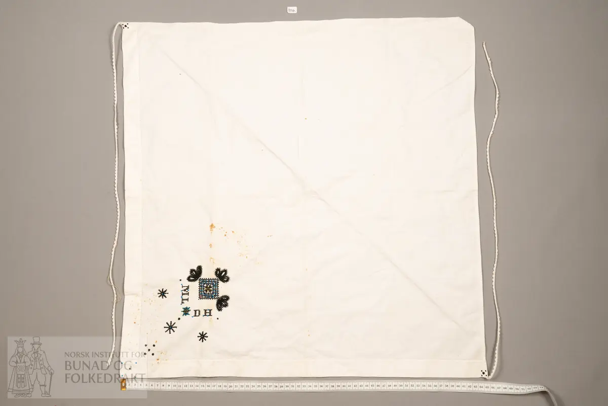 Skaut sydd av stødig, fast bomullslerret (24 tråder x 24 tråder per cm.). Bretta diagonalt. Broderi i eine snippen, av svart, tjukk silketråd og glasperler i mellomblå, mørk transparant blå, transparant grøn, transparant gul, og ei perle transparant raud.
Innbrodert med korssting initialane: "M.L.D.H."
Kjedesting, stilkesting og korssting.
Langs båe sider av den broderte snippen er bretta ein brei fald sydd ned med enkel holfald.
Også jare langs ei side og ein smalbretta fald sydd ned med små faldesting i den fjerde sida.
Knyteband av smalt, kvitt blondeband i bomull.

Om skautet i "Hovdatyet" av Eli Drønen: "Skautet var av lerret og sydd med svart tråd i korssting i nakken, ca. 67 x 67 cm. Skautebanda vart festa i to endar av skauten, dei er i ripsvevnad 58 cm x 1,3. Skautet vart lagt i trekant og sett på hua. Det vart kryssa bak, og skautspissane rakk til øyrene, og vidare vart skautebanda kryssa framme ca. 3 cm innpå skautet og ført vidare og knytt bak under skautet. Endene av banda vart putta innunder skautet. (...) Skautet var brukt utanpå rundhua, når dei gjekk til kyrkje, i gjestebod og i bryllaup."