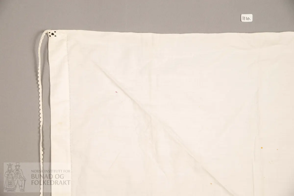 Skaut sydd av stødig, fast bomullslerret (24 tråder x 24 tråder per cm.). Bretta diagonalt. Broderi i eine snippen, av svart, tjukk silketråd og glasperler i mellomblå, mørk transparant blå, transparant grøn, transparant gul, og ei perle transparant raud.
Innbrodert med korssting initialane: "M.L.D.H."
Kjedesting, stilkesting og korssting.
Langs båe sider av den broderte snippen er bretta ein brei fald sydd ned med enkel holfald.
Også jare langs ei side og ein smalbretta fald sydd ned med små faldesting i den fjerde sida.
Knyteband av smalt, kvitt blondeband i bomull.

Om skautet i "Hovdatyet" av Eli Drønen: "Skautet var av lerret og sydd med svart tråd i korssting i nakken, ca. 67 x 67 cm. Skautebanda vart festa i to endar av skauten, dei er i ripsvevnad 58 cm x 1,3. Skautet vart lagt i trekant og sett på hua. Det vart kryssa bak, og skautspissane rakk til øyrene, og vidare vart skautebanda kryssa framme ca. 3 cm innpå skautet og ført vidare og knytt bak under skautet. Endene av banda vart putta innunder skautet. (...) Skautet var brukt utanpå rundhua, når dei gjekk til kyrkje, i gjestebod og i bryllaup."