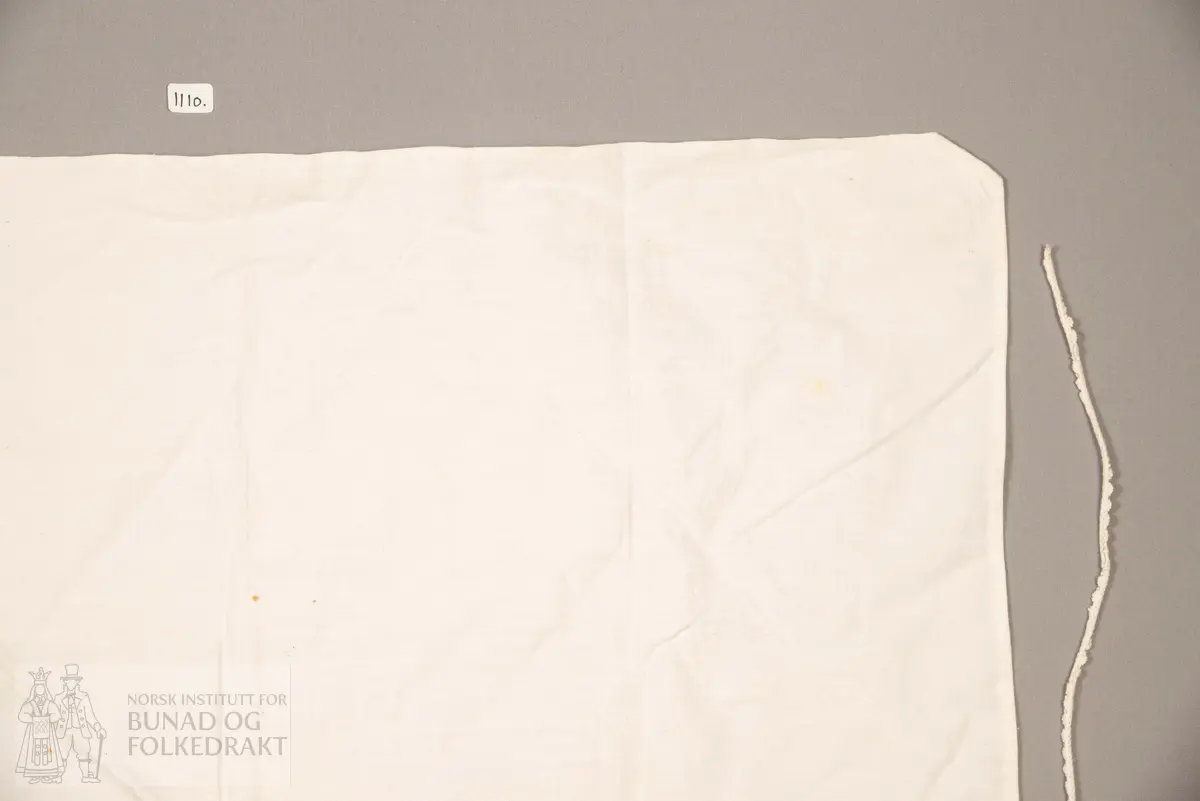 Skaut sydd av stødig, fast bomullslerret (24 tråder x 24 tråder per cm.). Bretta diagonalt. Broderi i eine snippen, av svart, tjukk silketråd og glasperler i mellomblå, mørk transparant blå, transparant grøn, transparant gul, og ei perle transparant raud.
Innbrodert med korssting initialane: "M.L.D.H."
Kjedesting, stilkesting og korssting.
Langs båe sider av den broderte snippen er bretta ein brei fald sydd ned med enkel holfald.
Også jare langs ei side og ein smalbretta fald sydd ned med små faldesting i den fjerde sida.
Knyteband av smalt, kvitt blondeband i bomull.

Om skautet i "Hovdatyet" av Eli Drønen: "Skautet var av lerret og sydd med svart tråd i korssting i nakken, ca. 67 x 67 cm. Skautebanda vart festa i to endar av skauten, dei er i ripsvevnad 58 cm x 1,3. Skautet vart lagt i trekant og sett på hua. Det vart kryssa bak, og skautspissane rakk til øyrene, og vidare vart skautebanda kryssa framme ca. 3 cm innpå skautet og ført vidare og knytt bak under skautet. Endene av banda vart putta innunder skautet. (...) Skautet var brukt utanpå rundhua, når dei gjekk til kyrkje, i gjestebod og i bryllaup."