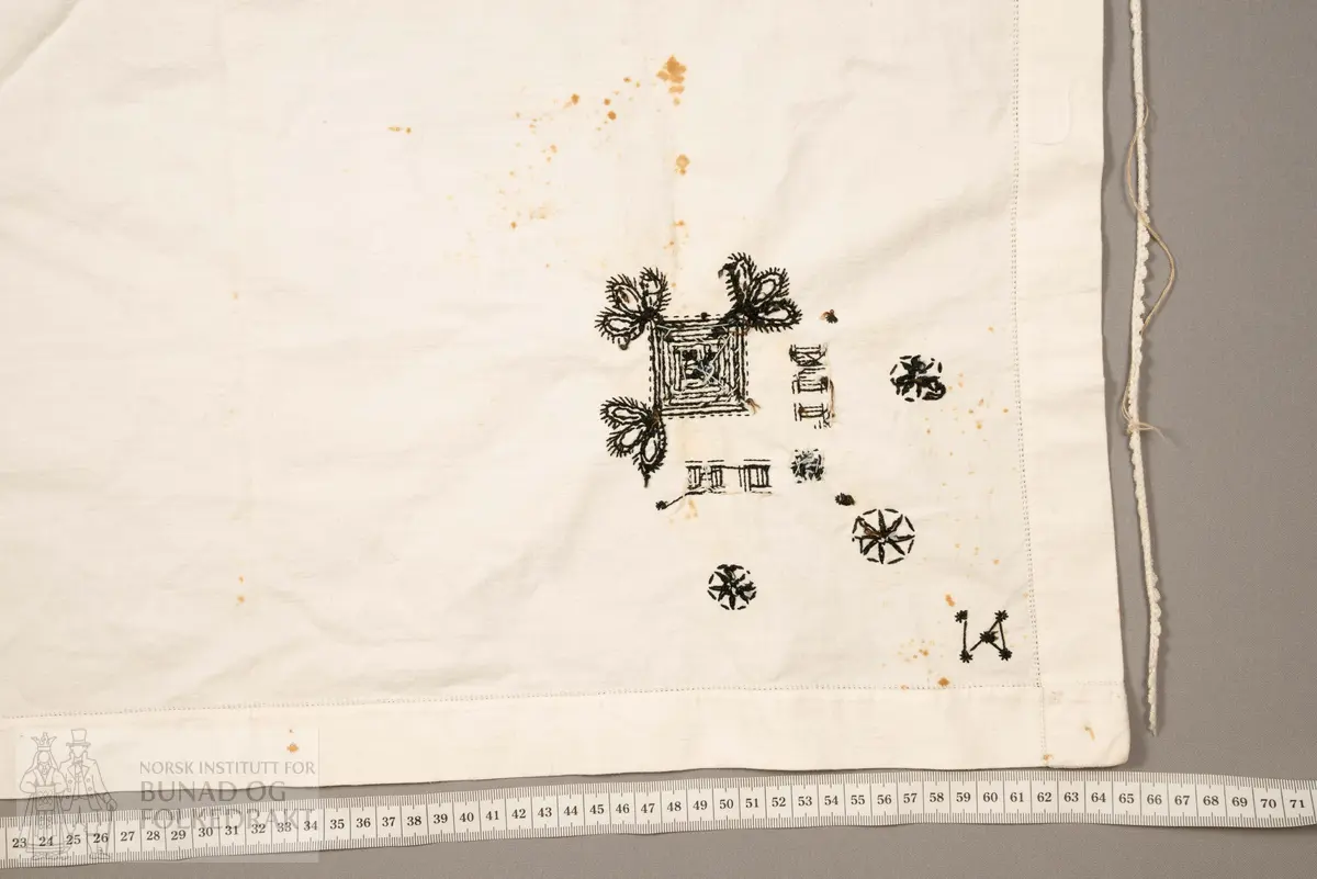 Skaut sydd av stødig, fast bomullslerret (24 tråder x 24 tråder per cm.). Bretta diagonalt. Broderi i eine snippen, av svart, tjukk silketråd og glasperler i mellomblå, mørk transparant blå, transparant grøn, transparant gul, og ei perle transparant raud.
Innbrodert med korssting initialane: "M.L.D.H."
Kjedesting, stilkesting og korssting.
Langs båe sider av den broderte snippen er bretta ein brei fald sydd ned med enkel holfald.
Også jare langs ei side og ein smalbretta fald sydd ned med små faldesting i den fjerde sida.
Knyteband av smalt, kvitt blondeband i bomull.

Om skautet i "Hovdatyet" av Eli Drønen: "Skautet var av lerret og sydd med svart tråd i korssting i nakken, ca. 67 x 67 cm. Skautebanda vart festa i to endar av skauten, dei er i ripsvevnad 58 cm x 1,3. Skautet vart lagt i trekant og sett på hua. Det vart kryssa bak, og skautspissane rakk til øyrene, og vidare vart skautebanda kryssa framme ca. 3 cm innpå skautet og ført vidare og knytt bak under skautet. Endene av banda vart putta innunder skautet. (...) Skautet var brukt utanpå rundhua, når dei gjekk til kyrkje, i gjestebod og i bryllaup."