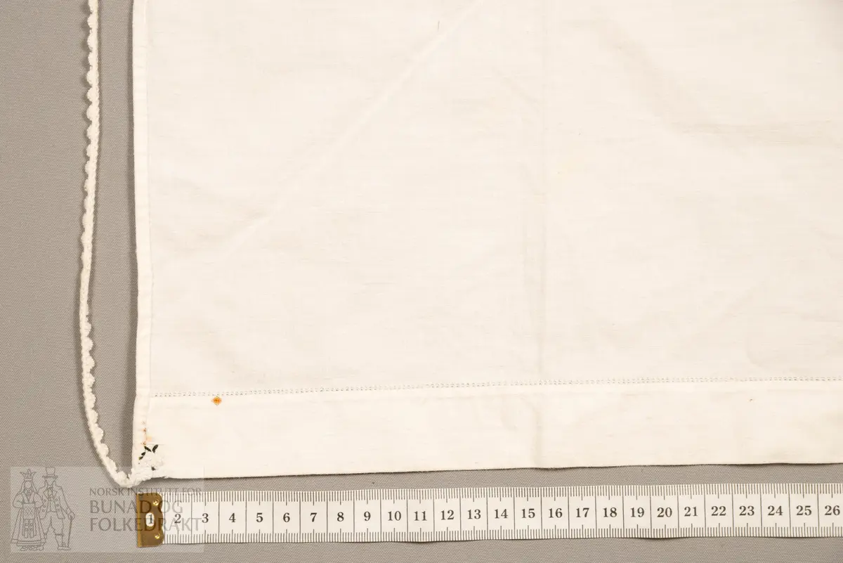 Skaut sydd av stødig, fast bomullslerret (24 tråder x 24 tråder per cm.). Bretta diagonalt. Broderi i eine snippen, av svart, tjukk silketråd og glasperler i mellomblå, mørk transparant blå, transparant grøn, transparant gul, og ei perle transparant raud.
Innbrodert med korssting initialane: "M.L.D.H."
Kjedesting, stilkesting og korssting.
Langs båe sider av den broderte snippen er bretta ein brei fald sydd ned med enkel holfald.
Også jare langs ei side og ein smalbretta fald sydd ned med små faldesting i den fjerde sida.
Knyteband av smalt, kvitt blondeband i bomull.

Om skautet i "Hovdatyet" av Eli Drønen: "Skautet var av lerret og sydd med svart tråd i korssting i nakken, ca. 67 x 67 cm. Skautebanda vart festa i to endar av skauten, dei er i ripsvevnad 58 cm x 1,3. Skautet vart lagt i trekant og sett på hua. Det vart kryssa bak, og skautspissane rakk til øyrene, og vidare vart skautebanda kryssa framme ca. 3 cm innpå skautet og ført vidare og knytt bak under skautet. Endene av banda vart putta innunder skautet. (...) Skautet var brukt utanpå rundhua, når dei gjekk til kyrkje, i gjestebod og i bryllaup."