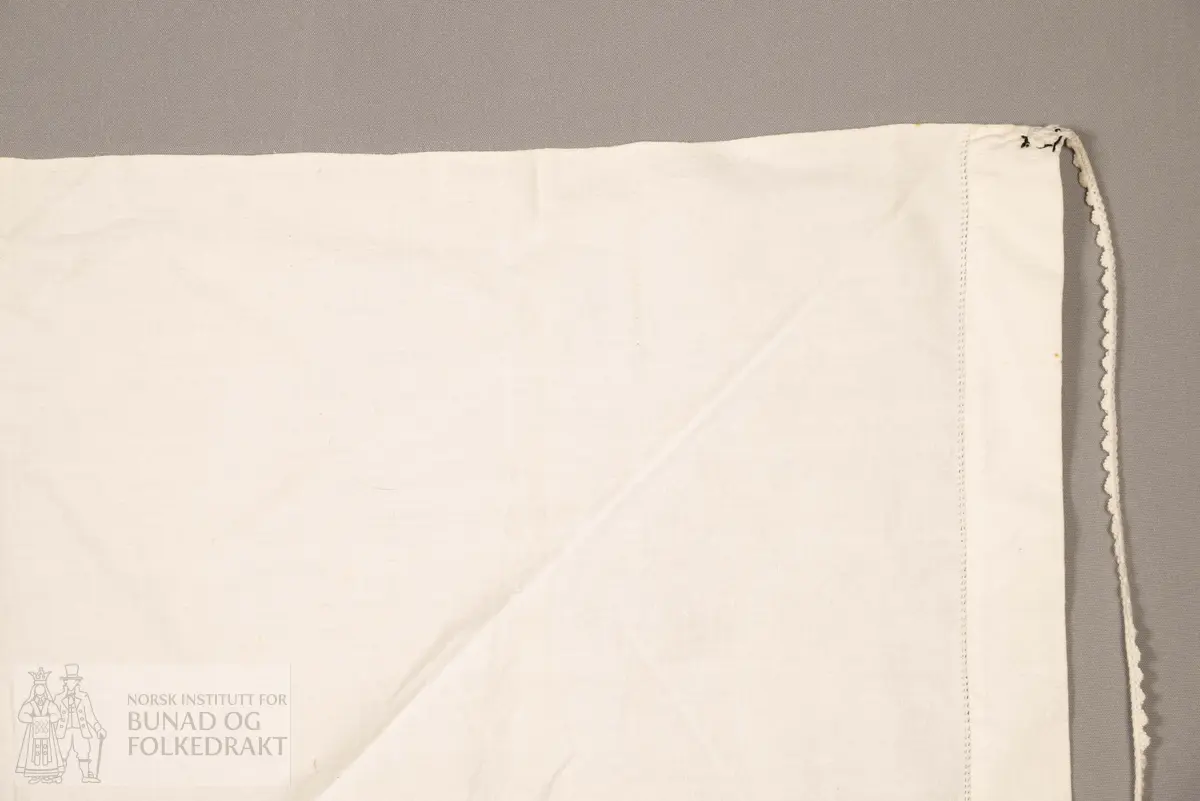 Skaut sydd av stødig, fast bomullslerret (24 tråder x 24 tråder per cm.). Bretta diagonalt. Broderi i eine snippen, av svart, tjukk silketråd og glasperler i mellomblå, mørk transparant blå, transparant grøn, transparant gul, og ei perle transparant raud.
Innbrodert med korssting initialane: "M.L.D.H."
Kjedesting, stilkesting og korssting.
Langs båe sider av den broderte snippen er bretta ein brei fald sydd ned med enkel holfald.
Også jare langs ei side og ein smalbretta fald sydd ned med små faldesting i den fjerde sida.
Knyteband av smalt, kvitt blondeband i bomull.

Om skautet i "Hovdatyet" av Eli Drønen: "Skautet var av lerret og sydd med svart tråd i korssting i nakken, ca. 67 x 67 cm. Skautebanda vart festa i to endar av skauten, dei er i ripsvevnad 58 cm x 1,3. Skautet vart lagt i trekant og sett på hua. Det vart kryssa bak, og skautspissane rakk til øyrene, og vidare vart skautebanda kryssa framme ca. 3 cm innpå skautet og ført vidare og knytt bak under skautet. Endene av banda vart putta innunder skautet. (...) Skautet var brukt utanpå rundhua, når dei gjekk til kyrkje, i gjestebod og i bryllaup."