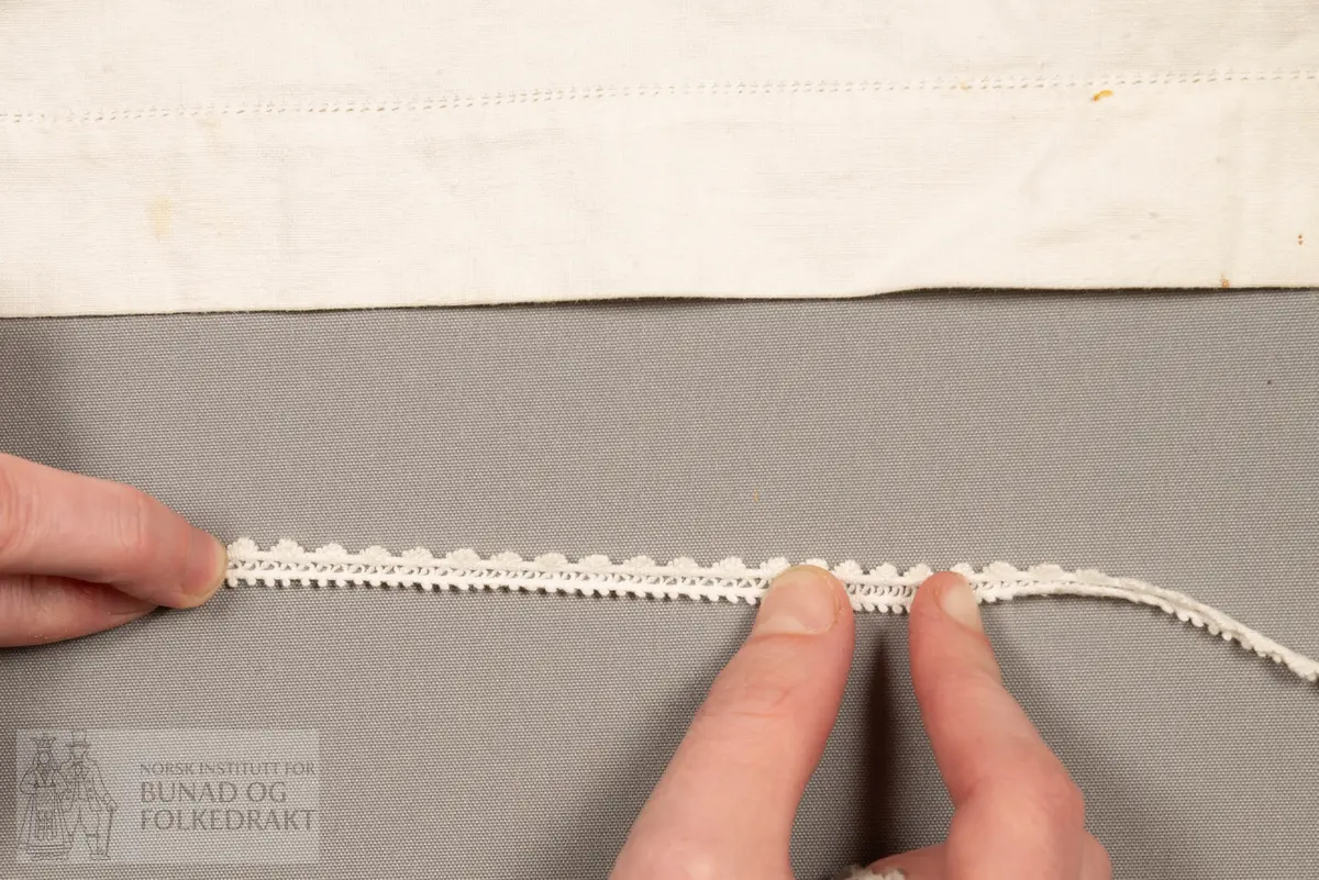 Skaut sydd av stødig, fast bomullslerret (24 tråder x 24 tråder per cm.). Bretta diagonalt. Broderi i eine snippen, av svart, tjukk silketråd og glasperler i mellomblå, mørk transparant blå, transparant grøn, transparant gul, og ei perle transparant raud.
Innbrodert med korssting initialane: "M.L.D.H."
Kjedesting, stilkesting og korssting.
Langs båe sider av den broderte snippen er bretta ein brei fald sydd ned med enkel holfald.
Også jare langs ei side og ein smalbretta fald sydd ned med små faldesting i den fjerde sida.
Knyteband av smalt, kvitt blondeband i bomull.

Om skautet i "Hovdatyet" av Eli Drønen: "Skautet var av lerret og sydd med svart tråd i korssting i nakken, ca. 67 x 67 cm. Skautebanda vart festa i to endar av skauten, dei er i ripsvevnad 58 cm x 1,3. Skautet vart lagt i trekant og sett på hua. Det vart kryssa bak, og skautspissane rakk til øyrene, og vidare vart skautebanda kryssa framme ca. 3 cm innpå skautet og ført vidare og knytt bak under skautet. Endene av banda vart putta innunder skautet. (...) Skautet var brukt utanpå rundhua, når dei gjekk til kyrkje, i gjestebod og i bryllaup."