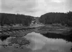 Skogsbygd med älvinbyggnad för flottning, samt bebyggelse.