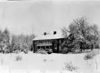 Herrgårdsliknande byggnad i snölandskap.