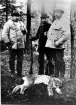 Tre jägare med bössor, samt ett skjutet lodjur.