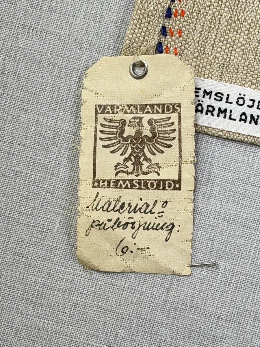 Duk gjord av halvlinne i sålldräll och broderi utfört med både bomulls- och lingarn i förstygn, raka kors- ovanpå sneda korsstygn och stjälksöm. Duken har 1cm bred dubbelvikt fåll runt om samt sneda hörn, vilka är sydda med kaststygn.