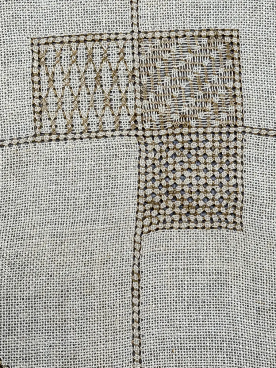 Åttkantig duk gjord av linneväv med 10tr/cm i tuskaft och broderi utfört med lingarn i sex olika bottensömmar. Dukens kanter har en 16mm bred dubbelvikt fåll runt om fastsydd med kaststygn samt en myrgångs- söm.