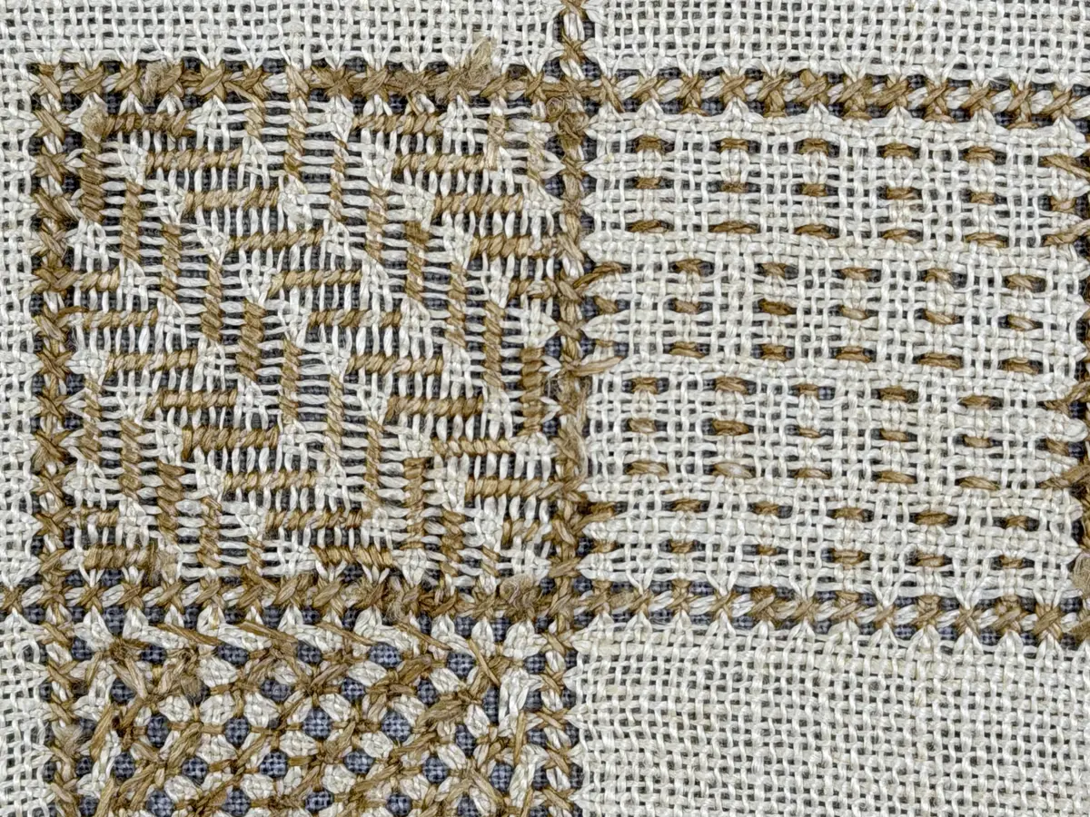 Åttkantig duk gjord av linneväv med 10tr/cm i tuskaft och broderi utfört med lingarn i sex olika bottensömmar. Dukens kanter har en 16mm bred dubbelvikt fåll runt om fastsydd med kaststygn samt en myrgångs- söm.