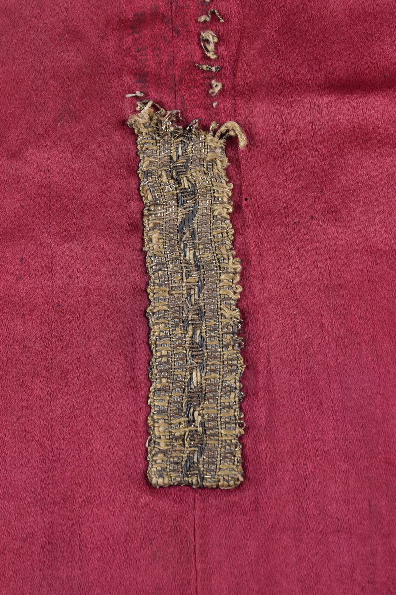 På mässhakens framsida finns en korsformad besättning av vävda guldband. Ryggsidan har även den en korsformad besättning, vilken föreställer Kristus på korset. På korsarmarna finns evangelisternas sinnesbilder. I nedre kanten av korset finns två förenade vapen och därunder en helgonbild. 

Enligt liggare:
"Messhake av rött siden med broderier från 1500-talet; Kristus på korset; på korsarmarna evangelisternas sinnebilder; under korset tvänne förenade vapen, därunder en helgonbild med Andreaskorset"


Neg.nr: 1984-04