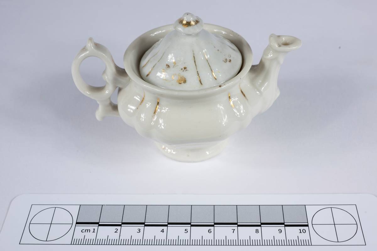 Ofärgad glasyr med obränd gulddekor.
:1 Kaffekanna med lock, H 65 mm.
:2 Sockerskål med lock, H 60 mm.
:3 Gräddkanna, H 55 mm.
:4 Korg, H 60 mm.
:5 Kaffekopp med fat, H 25 mm.
:6 Fat (med druvklase i relief) Diam 60 mm.
:7 Vas, H 60 mm.
:8 Vas, H 60 mm.