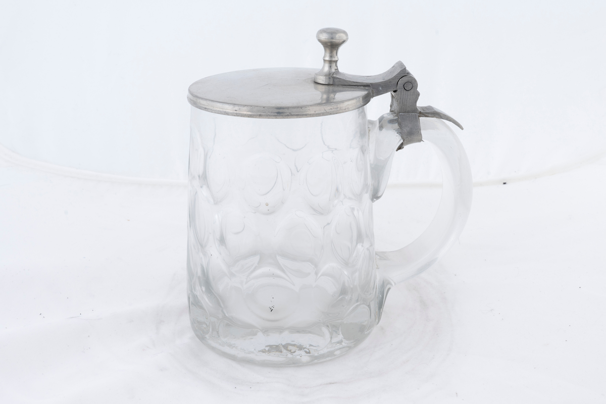 Sejdel av glas med lock av tenn. Pressat mönster i glaset.
