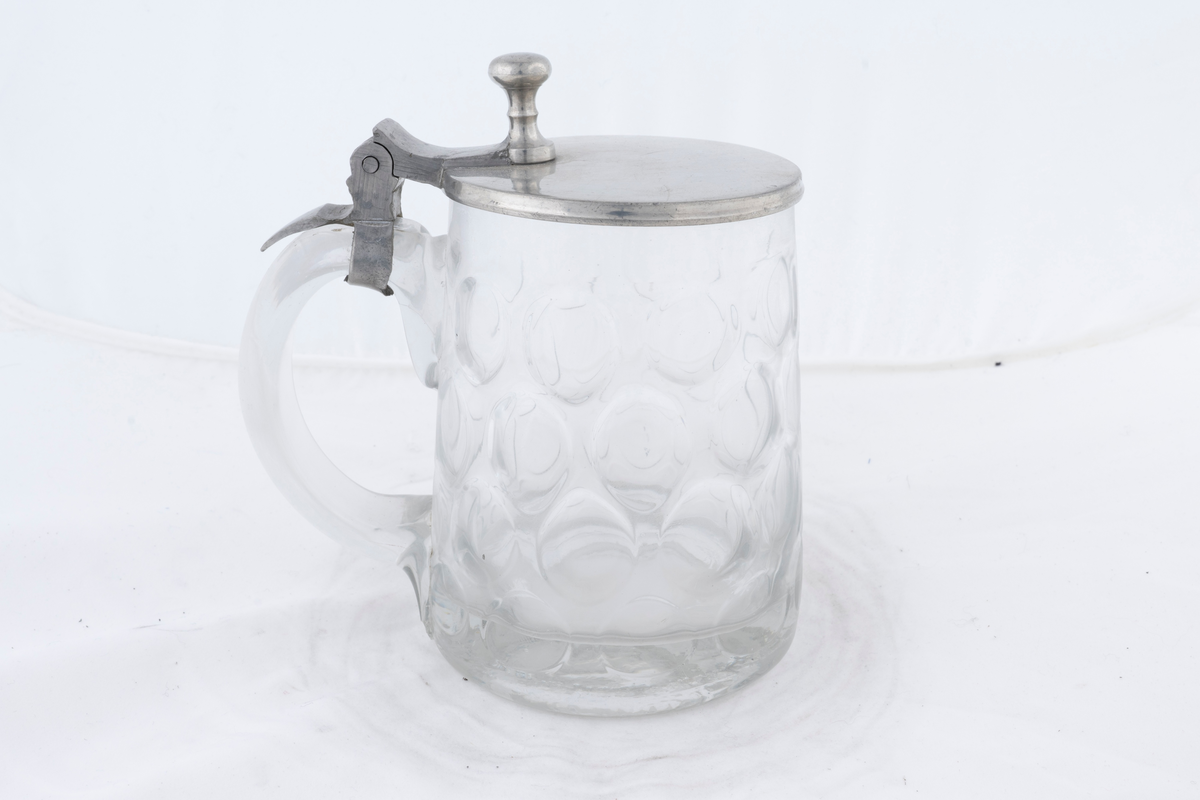 Sejdel av glas med lock av tenn. Pressat mönster i glaset.
