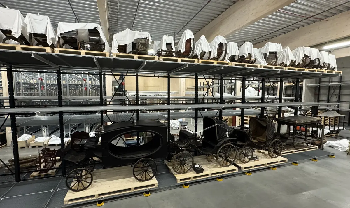 Bilde av gamle trekkvogner og sleder i magasinet ved Anno bevaringssenter.