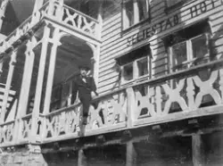 Ein mann sit på gelendert til Seljestad Hotel ant. på 1920-t