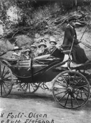 To kvinner og tre menn på utflukt i ein karjol med skysskar 