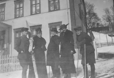 Otto Aamodt jr. med ski, to kvinner, Otto Aamodt og en gutt på ski. Utenfor Aamodtgården.