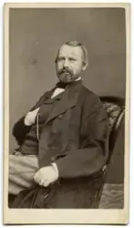 Porträtt på en man i helfigur, sittande.