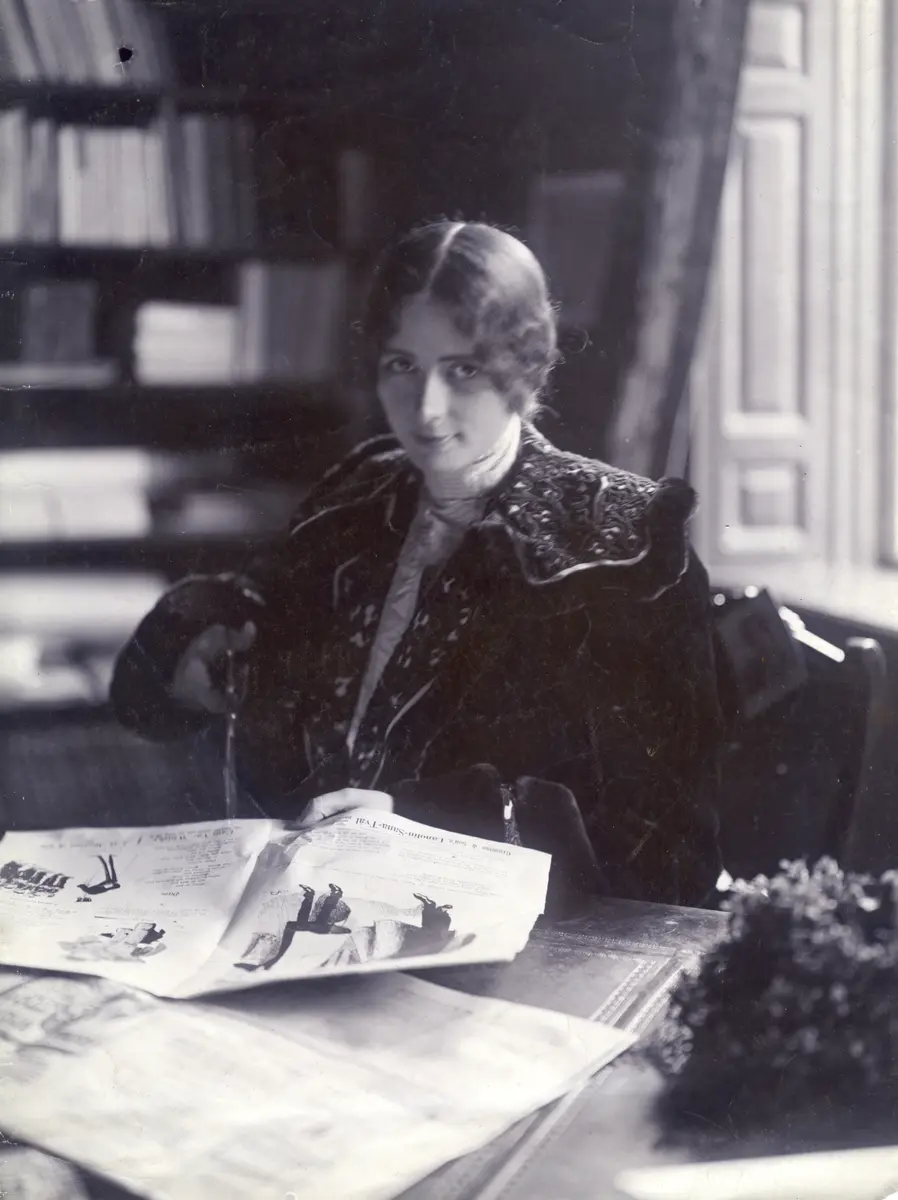 Cléo de Mérode bläddrar i tidning på Söndags-Nisses redaktion 1903.