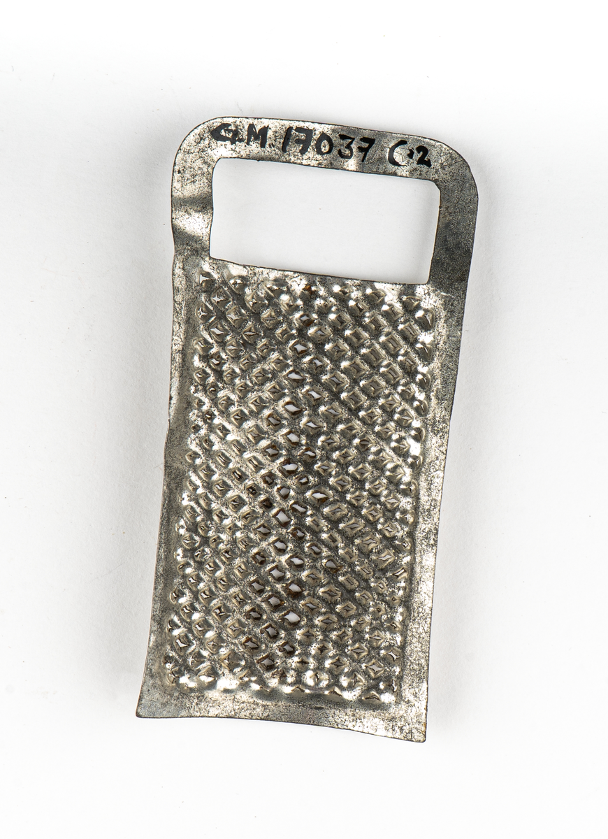 Rivjärn, 1-3, av vitmetall. En rektangulär skiva välvd.
Ytan fylld av rivtaggar. upptill ett format handtag.
1 och 2 är större än 3.

Tillhör leksakssamling GM17037a-k.