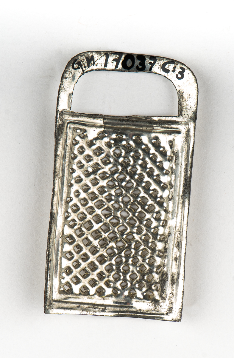 Rivjärn, 1-3, av vitmetall. En rektangulär skiva välvd.
Ytan fylld av rivtaggar. upptill ett format handtag.
1 och 2 är större än 3.

Tillhör leksakssamling GM17037a-k.